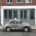 ein grauer Morris Minor steht in London vor einem Gebäude mit einer grauen Fassade